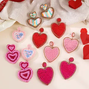 Vista dettagliata di orecchini a cuore di perline, simpatici gioielli di San Valentino rosa e rossi.