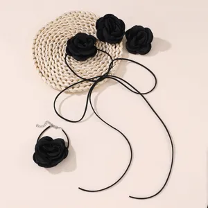 Detail view of handmade black fabric rose choker necklace and matching bracelet, elegant floral.