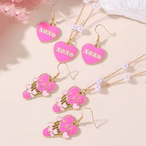 Cute pink heart pendant necklace and earrings set with faux pearls and sweet love details.