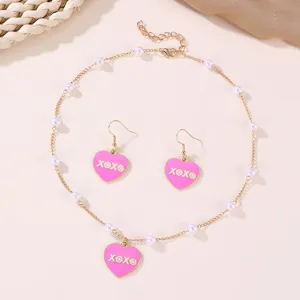 Charming pink heart enamel pendant necklace and earrings set with delicate pearl chain details.