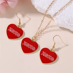 Close-up detail of the red heart enamel pendant necklace and matching earrings set.