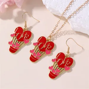 Close-up detail shot of the red heart hot air balloon necklace and earrings jewelry.