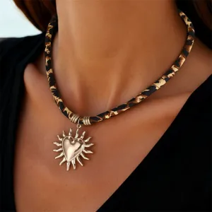 Nahaufnahme Detail der Leo-Muster-Choker-Halskette mit stylischem Sonnen-Herz-Anhänger.