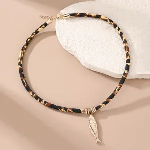 Detailansicht der stylischen Leo-Muster-Kette mit Stoffband und einem niedlichen Metallfisch.