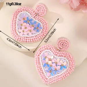 Orecchini a cuore in perline con paillettes floreali, design elegante, dettaglio di gioielli.