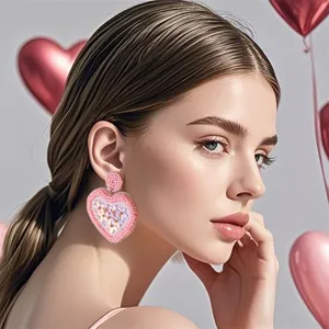 Primo piano dettagliato di orecchini a cuore in perline rosa in stile studio San Valentino.