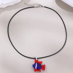 Nahaufnahme des blau-roten Glasfisch-Anhängers an einer schwarzen Wachskordelkette.