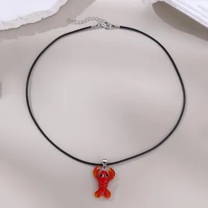 Detailansicht einer schwarzen Wachskordel Kette mit einem niedlichen roten Hummer Glasanhänger.