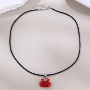 Detailansicht der schwarzen Damen Kordelkette mit einem roten Glas Krabben Anhänger.