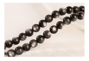 Macro shot of silver sheen obsidian beads showing natural chatoyancy
