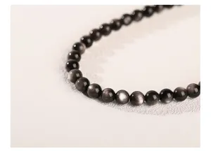 Macro detail of silver obsidian beads showing natural silver sheen and smooth texture