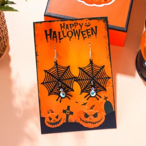 Detailed view of Halloween spider web earrings on a themed decorative gift card.