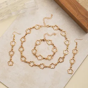 Detail des goldfarbenen Schmucksets mit hohlen Blumen, Halskette, Armband und passenden Ohrringen.