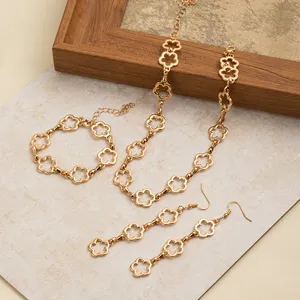 Detailansicht des goldenen Kleeblatt Schmucksets, elegante hohle Blumenkette, Armband und Ohrringe.