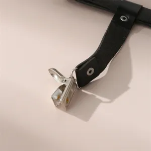 Detail van metalen klem voor leren kousenband, gothische accessoire in close-up.