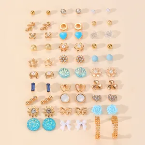 Set di orecchini a lobo misti, con dettagli dorati, blu e perle per donne eleganti.