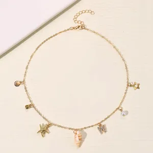 Goldene Strand Muschel Stern Halskette Detail mit exquisiten Anhängern und klaren Strasssteinen.