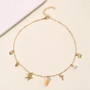 Detail der goldenen Strand-Halskette mit Seestern, Muschel, Perlen und Strass-Buchstaben.