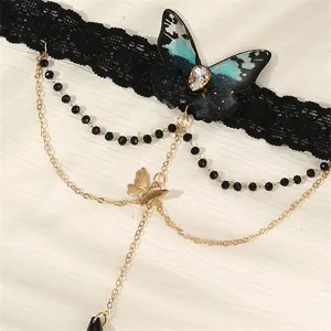 Gothischer schwarzer Spitzen-Armketten-Schmuck mit blauem Schmetterlingsanhänger und goldenen Ketten.