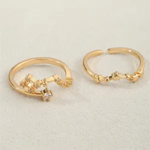 Nahaufnahme von zwei verstellbaren vergoldeten Sternbild-Ringen mit funkelnden Zirkonia-Steinen.