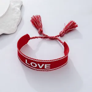 Red woven bracelet with LOVE letter embroidery and delicate tassels, ideal couple hand jewelry.
