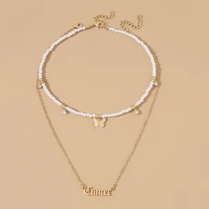 Doppelte Perlen-Choker-Halskette mit goldenem Schmetterlingsanhänger und Krebs-Buchstabe.