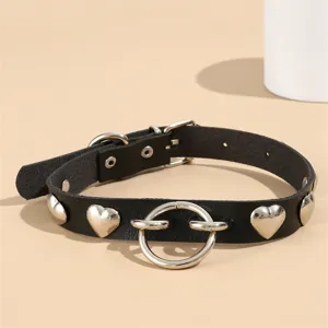 Schwarze Leder-Choker-Halskette mit Herz-Metallnieten und Ring-Detail im Nahbereich.