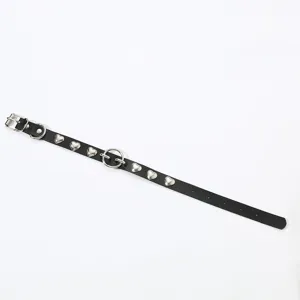 Schwarze Leder Choker Halskette mit silbernen Herznieten und Metallring Detail Nahansicht.