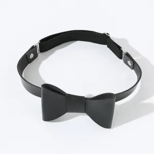 Detailopname van de zwarte lederen strikaccessoire met elastische band en metalen gespen.