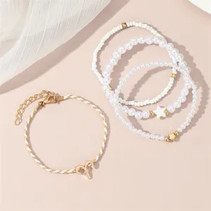 Detailansicht des mehrlagigen Perlen- und Perlen-Sternzeichen-Armbandsets mit goldenem Stern.