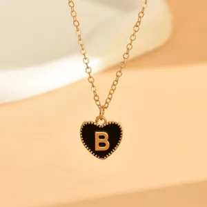 Nahaufnahme Detailansicht einer Goldkette mit einem schwarzen Emaille Herz Anhänger.