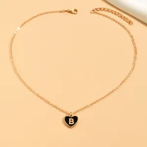 Vergoldete Kette mit einem schicken schwarzen Emaillie-Herz-Anhänger und Initialdetail.