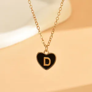 Nahaufnahme der Goldkette mit einem schwarzen Emaileherzen und dem Buchstaben D Anhaenger.
