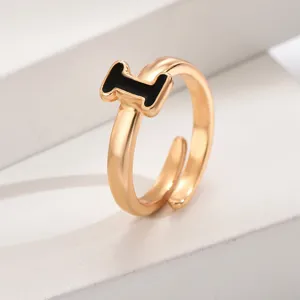 Verstellbarer goldfarbener Ring mit schwarzem Emaillendetail, minimalistischer Modeschmuck.