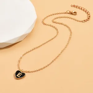 Goldfarbene Kette mit schwarzem Emaile-Herz-Anhänger und feinem Buchstaben E Detail.