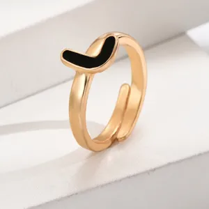 Nahaufnahme eines stilvollen goldenen offenen Rings mit schwarzem Emaille-Detail.