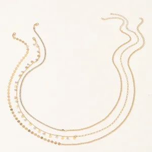 Detail view of layered gold waist chain featuring delicate sequin discs and sparkling rhinestones.