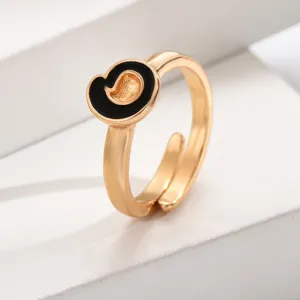 Nahaufnahme des stilvollen goldenen offenen Rings mit elegantem schwarzem Emaille-Akzent.