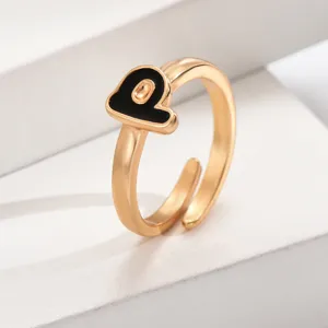 Goldener verstellbarer Initialenring mit schwarzem Emailleschmuck, stilvoll und modisch.