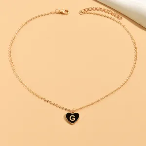 Elegante goldfarbene Halskette mit schwarzem Emaile-Herzanhänger und Buchstabe G.