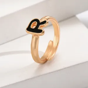 Detailansicht des modischen goldenen verstellbaren offenen Rings mit schwarzem Emailleschmuck.