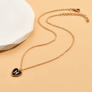 Goldfarbene Kette mit schickem schwarzen Emaile-Herzanhänger und Buchstabe H Detail im Nahbereich.