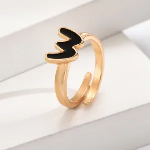 Verstellbarer goldfarbener Buchstabenring mit schwarzem Emaildesign minimalistischer Schmuck.