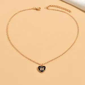 Goldfarbene Kette mit schwarzem Emaille Herz und Buchstabe W Anhänger, minimalistischer Schmuck.