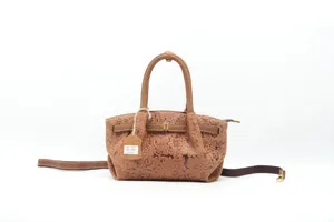 Detailed view of the vintage embossed leather handbag, showing exquisite floral pattern and strap.
