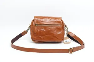 Detail shot of vintage brown genuine leather crossbody bag with metal zipper and adjustable strap.