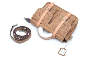 Detailed view of vintage embossed leather messenger bag, showing detailed texture and strap.