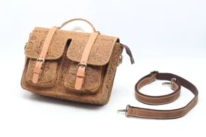 Close-up view of vintage brown leather messenger bag with floral tooling, dual front pockets and strap.
