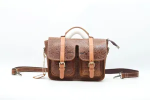 Detailed view of brown vintage embossed leather satchel bag with double front pockets.