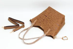Detailed view of the brown embossed genuine leather tote bag with handle and strap accessories